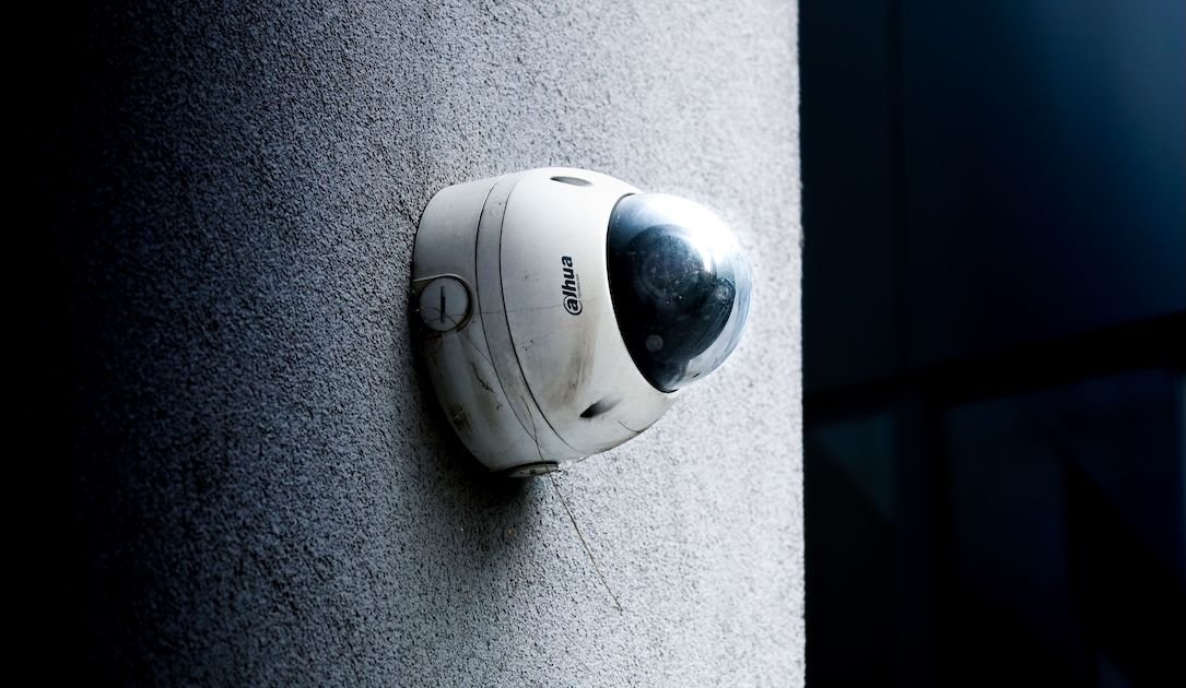 Câmera de vigilância Dahua do tipo domo presa numa parede externa